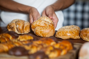 Mid-section of woman holding bread at counter