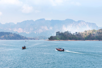 Fototapeta premium longtail boats sailing in lake of ratchaprapha dam at khao sok national park, Surat Thani province,Thailand