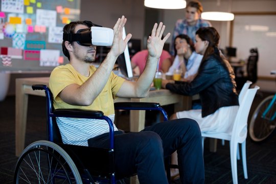 Physically disabled man on wheelchair using VR headset