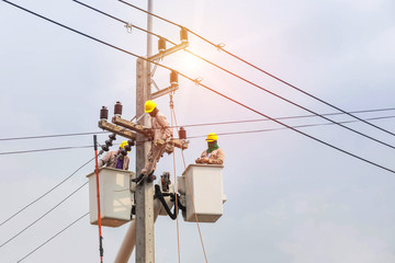  Electricians repairing wire of the power line with bucket hydraulic lifting  © Soonthorn