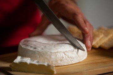 Staff cutting cheese at counter in market