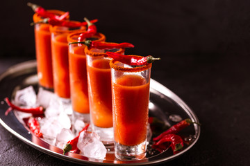 Bloody Mary cocktail with chili pepper, ice and celery.