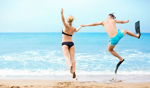Happy couple jumping in the sea