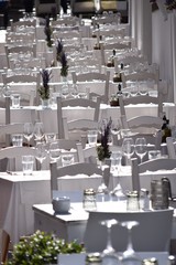 Tische fein gedeckt, alles in weiß auf Kopfsteinpflaster mit Stufen - Restaurant mit Außenterrasse in sonnigen Gefilden