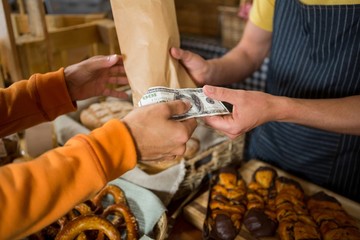Customer paying bill by cash at bread counter