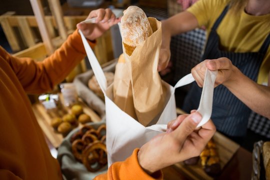 Male customer receiving a parcel from staff at counter