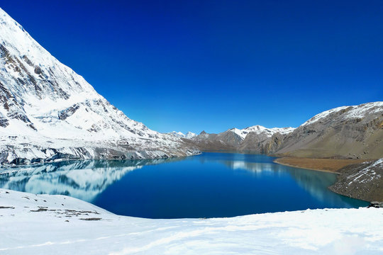 Tilicho Lake in Annapurna Conservation Area, Nepal. Mountains reflecting in the water of the lake.