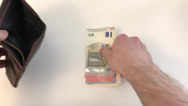 Hand vom Mann nimmt Geld aus Portemonnaie und z&auml;hlt verschiedene Euro Scheine