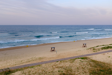Ocean waves near the lonely beach with benches