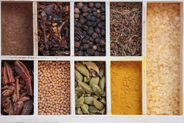 Spices in a box (set): cinnamon, baden, turmeric, mustard, cardamom, paprika, pepper, cumin, salt