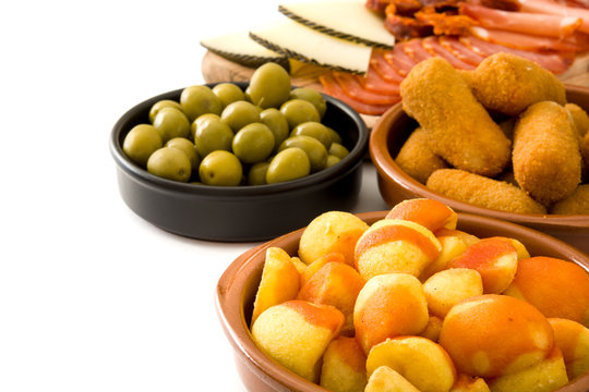 Traditional spanish tapas. Croquettes, olives,  ham and patatas bravas isolated on white background
