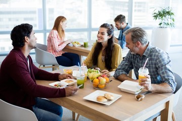 Creative business team discussing while having meal