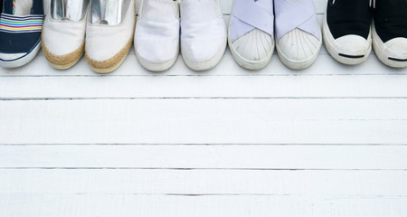 The shoes are placed on a white wooden floor.