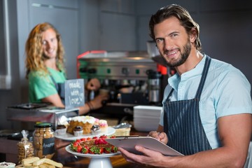 Male staff maintaining a record on clipboard at counter