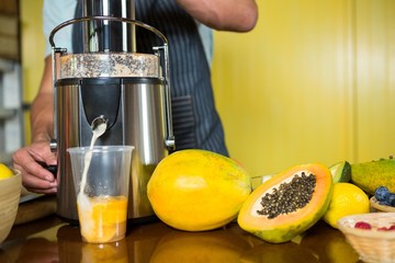 Shop assistant preparing papaya juice