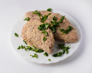 Raw semifinished cutlet with lettuce on plate