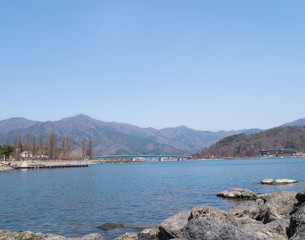 Fototapeta premium Landscape of the bridge over lake Kawaguchi, mountain and blue sky - Kawaguchiko, Japan