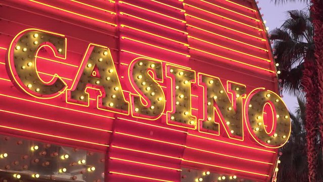 Flashing Casino sign in gambling city tilt establishing shot.