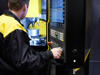 Worker controls CNC machine