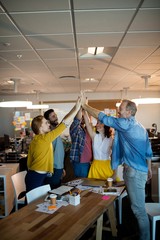 Creative business team giving a high five to each other