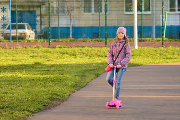 Little girl riding a scooter