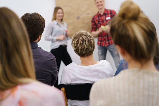 m&auml;nner und frauen h&ouml;ren einem vortrag zu
