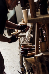 Senior sculptor working in his workshop. He choosing the right tool.