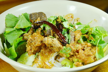 rice noodles dressing spicy chop pork and bone red cotton tree sauce with vegetable on bowl