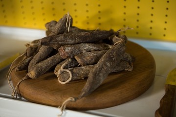 Close-up of dry sausage in wooden board