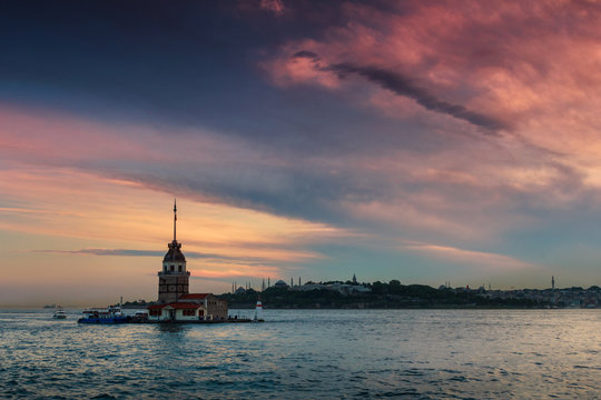Beautiful landscape of Maiden's tower (Tower of Leandros) at sunset. Dramatic cloudy sky. In the distance are such landmarks as Hagia Sophia, Blue Mosque and Topkapi Palace. Istanbul. Turkey.