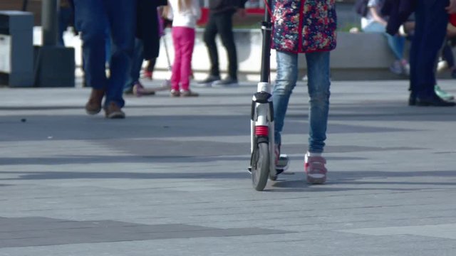 The child is riding a scooter.