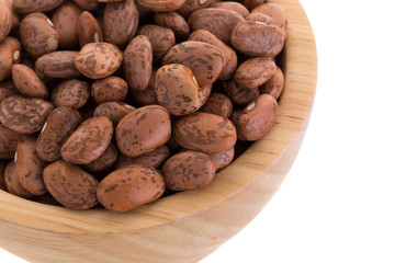 pinto beans  in a wooden bowl isolated on a white background.