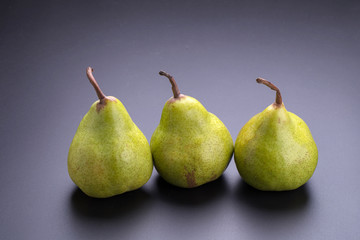 Fototapeta na wymiar Close up of fresh green pears over black background