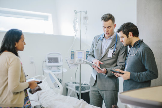 Male Doctor Training Coworkers Over Tablet Computer In Medical School