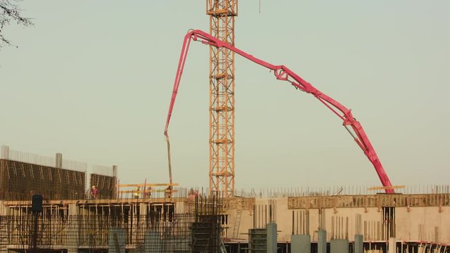 Lublin, Poland - April 2017: Construction workers at work building and using a concrete mixer machine. Long shot