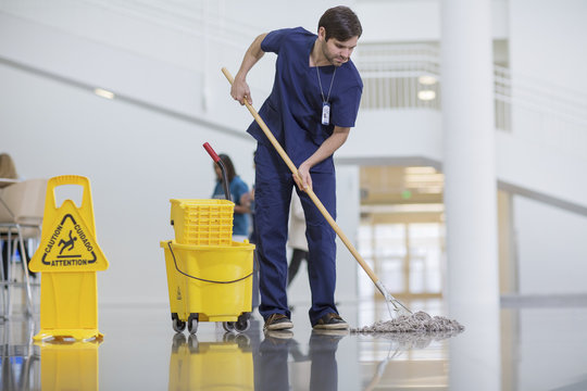 Male worker cleaning hospital floor