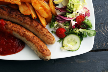 grilled sausages and potatoes and salad