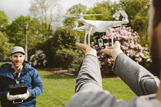 Men operating drone in park