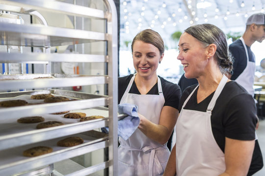 Female chefs examining cookies at restaurant kitchen