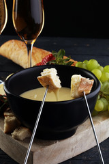 Gourmet Swiss fondue dinner with assorted cheeses on a board and