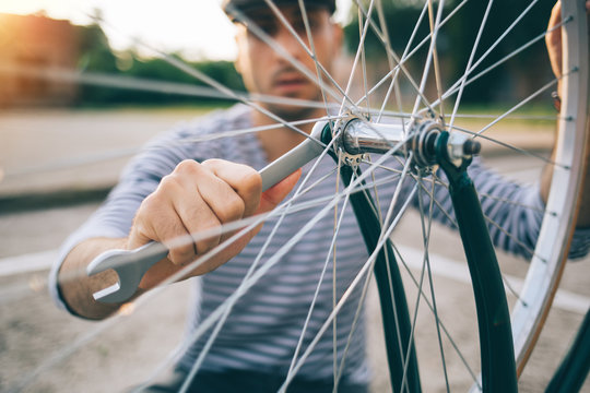 Man tightening wheel on bicycle