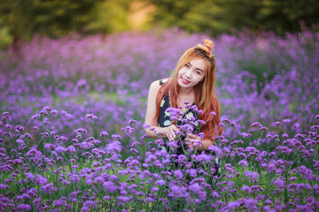 Obraz na płótnie Canvas Beautiful Asian girl is smiling in purple flower field