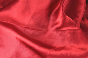 Red fabric background texture wave. Pink silk fabric close-up with an overflow of light and a...