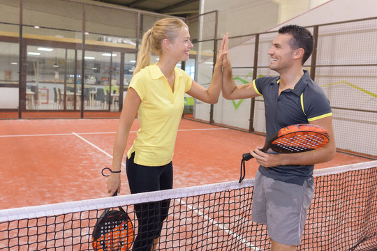 happy couple playing tennis indoor tennis court