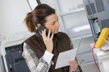 Female electrical technician using smartphone