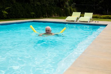 Senior man swimming with inflatable tube