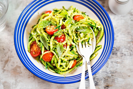 Spiralled courgette spaghetti with green pesto and cherry tomatoes 