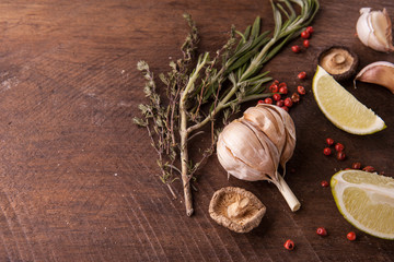 Garlic, spices and herbs on the wooden background. Top view, copy space for text
