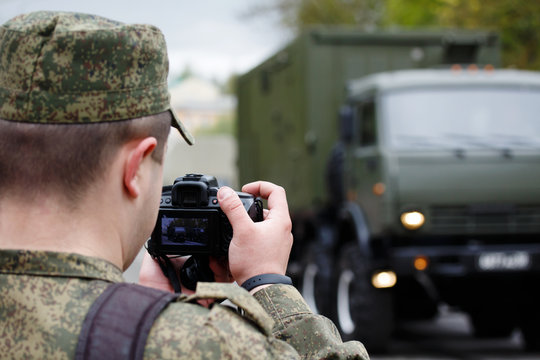 Army journalist photographer. Soldier takes picture military vehicle