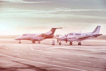 Private jet planes parking at the airport. Private airplanes at sunset,